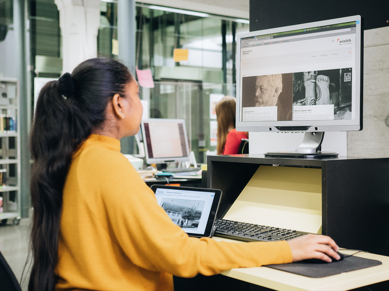 Frau schaut die Bilddatenbank am Computer an