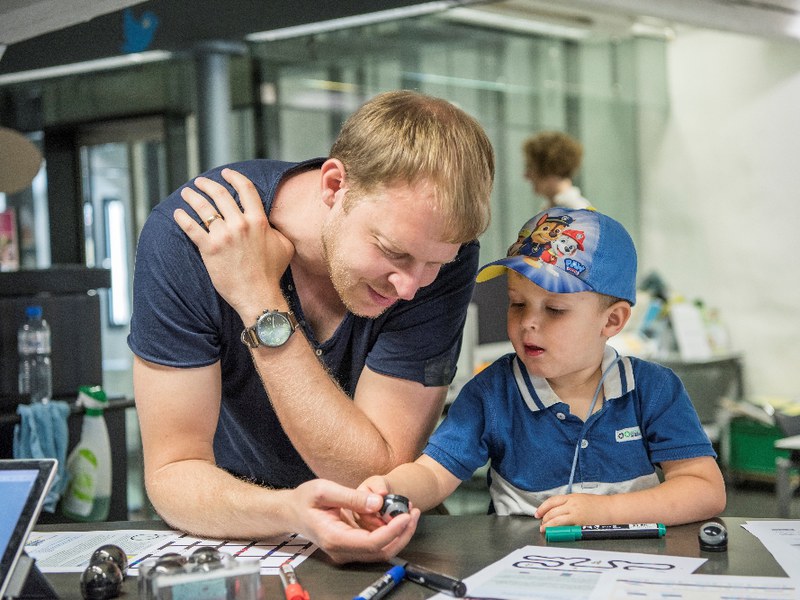 Vater erklärt Kind Lego-Roboter