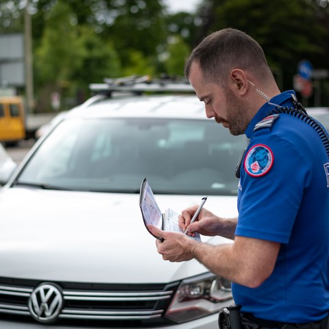 Polizist schreibt Busse. Vergrösserte Ansicht